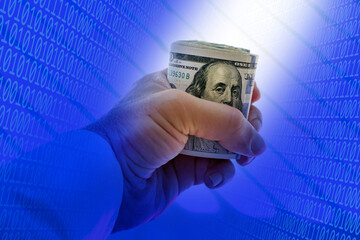 close up businessman hand holding rolled up American hundred dollars pile over blue binary codes
