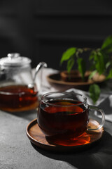 Tasty hot tea in cup on grey table, closeup
