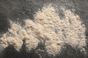 Scattered flour on grey textured table, top view