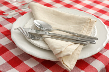 Stylish setting with cutlery, plates and napkin on table, closeup