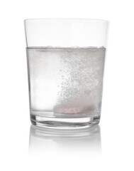 Effervescent pill dissolving in glass of water isolated on white