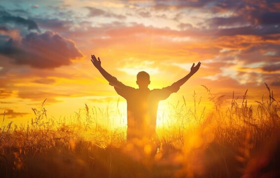 Concept for International Human Rights Day: Silhouette of man raising his hands during sunset