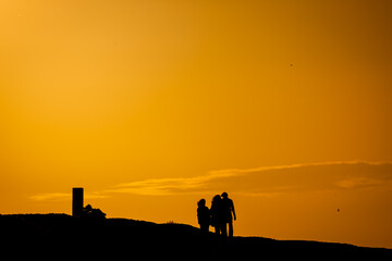 Family walking into orange sunset