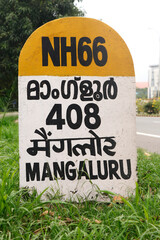 Fototapeta premium mile stone sign board (travel guide) located beside of national highway in kerala india