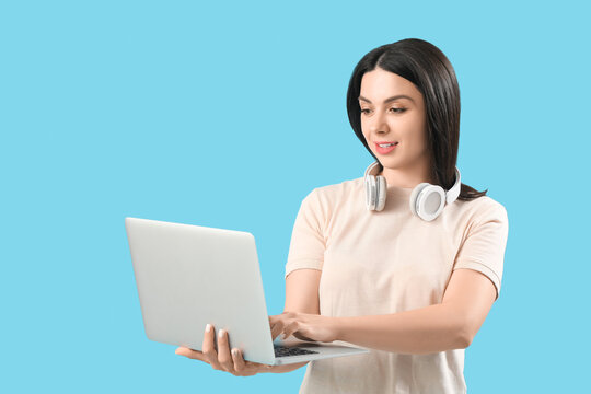 Female programmer working with laptop on blue background