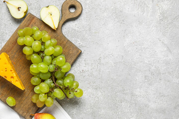 Wooden board with fruits and cheese on grunge grey kitchen table