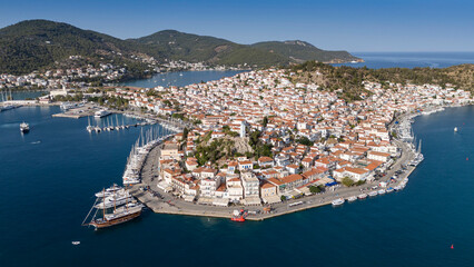 Aerial panorama of the city and harbor of Poros island in the Saronic Gulf, Greece, during a colorful summer sunset