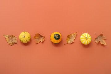 Autumn composition with pumpkins and leaves on orange background