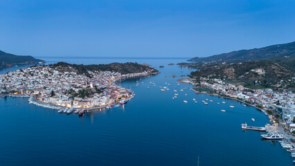 Fototapeta premium Aerial panorama of the city and harbor of Poros island in the Saronic Gulf, Greece, during a colorful summer sunset