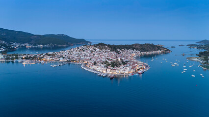 Aerial panorama of the city and harbor of Poros island in the Saronic Gulf, Greece, during a colorful summer sunset © Suzi