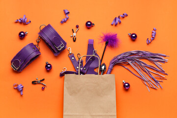 Christmas composition with shopping bag and sex toys on orange background