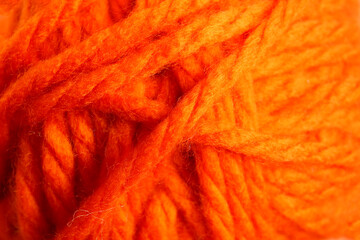 Orange wool yarn for knitting as background, closeup