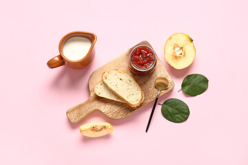 Delicious breakfast with sweet toasts, quince jam and jug of milk on pink background