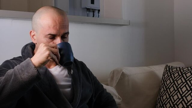 48 year old Brazilian man drinking tea and looking at the camera with a sad look.