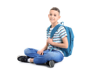 Cute schoolboy with blue backpack on white background