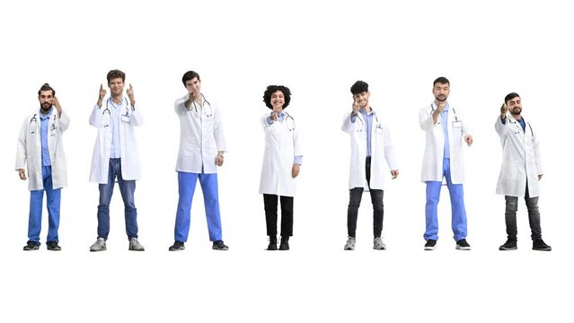 A group of doctors, in full height, on a white background, points forward