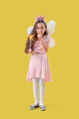 Cute little fairy with wand showing silence gesture on yellow background
