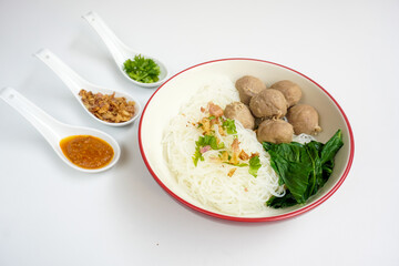 Bakso Meatballs and Rice Noodles with Soup Served Chili Sauce, Indonesia Food Style Popular Street Food served on bowl with chili sauce, chopped celery and fried onions sideview