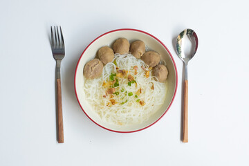 Bakso Meatballs and Rice Noodles with Soup Served Chili Sauce, Indonesia Food Style Popular Street Food served on bowl with fork and spoon