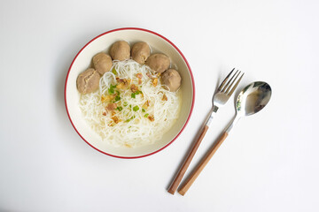 Bakso Meatballs and Rice Noodles with Soup Served Chili Sauce, Indonesia Food Style Popular Street Food served on bowl with fork and spoon