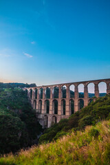 Obraz premium Aqueduct between mountains at sunrise with cloudy sky in arcos del sitio in tepotzotlan state of mexico 