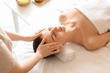 Young woman getting head massage on couch in spa salon, closeup