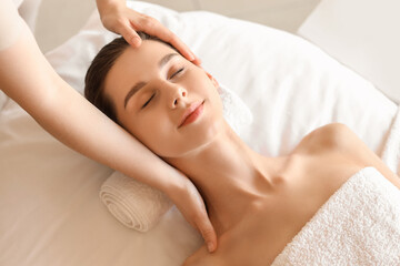 Obraz premium Young woman getting head massage on couch in spa salon, closeup