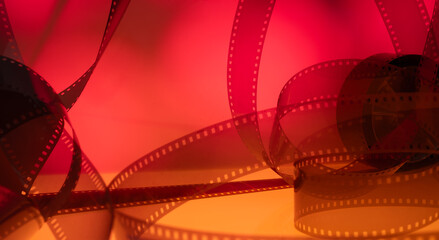 real film strip illuminated with multi-colored light for a cinematic background with film. film...