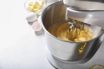 Making dough in bowl of stand mixer on white table, closeup. Space for text