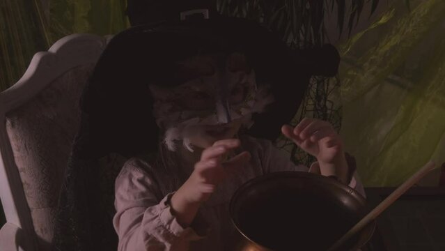 young witch stirs mystical potion in copper cauldron, adding charm to Halloween party atmosphere, magical potion, whimsical charm