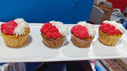 High Angle View of Sweet Cupcake with red and white cream topping and candy sprinkles