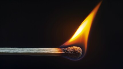 Burning matchstick with bright flame against a dark background.