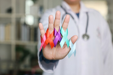 World Cancer Day. Professional Doctor Hand Holding Colorful Ribbons On Palm For Cancer Awareness
