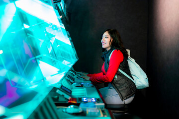 A young Latina woman smiling while playing arcade games in Akihabara, Tokyo, Japan, with glowing...