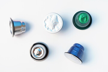 Metal reusable capsules and plastic capsules for coffee machine on a white background close-up.