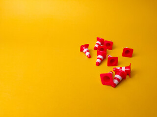 Mini plastic cones scattered on a yellow background