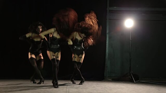 Dancing girls in stockings on black background