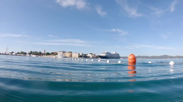 Swimming in warm blue Adriatic with city panorama of Zadar in the background, Croatia in the morning