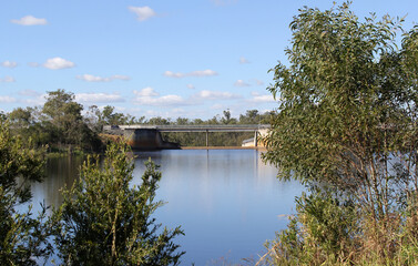 Bridge crossing a serene body of water surrounded by trees at Lake Monduran in Queensland, Australia