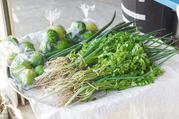Vegetables on the tray for sale such as  lime, spring onions, coriander, shallots for sale in Thailand