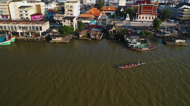 Aerial view around a fishing boat in front of the skyline of Surat Thani, Thailand