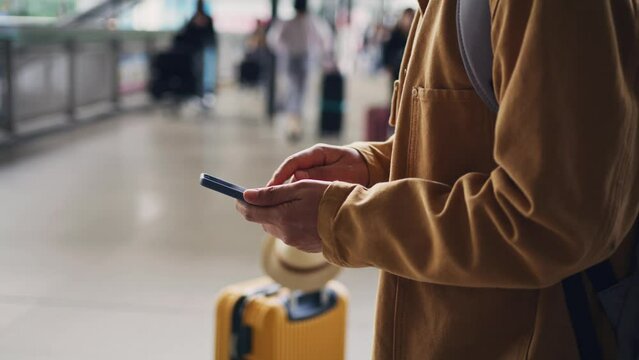 Hands of traveler using smartphone checking his flight status and self check-in, travel and tourist in airport and transportation