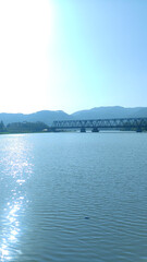 beautiful view of serayu river with train bridge, hill and clear blue sky