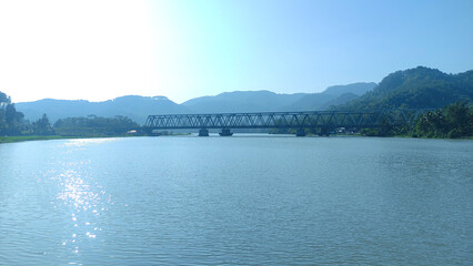 beautiful view of serayu river with train bridge, hill and clear blue sky