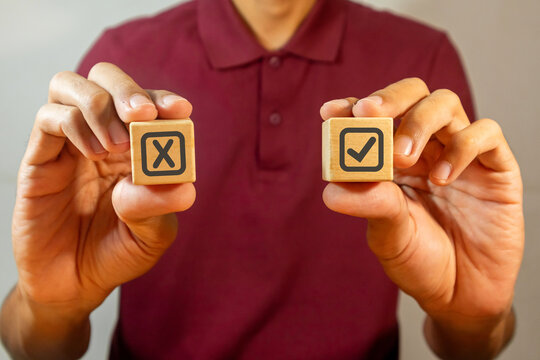 Man holding wooden blocks with Yes No icon or correct wrong icon. Yes Or No choice.