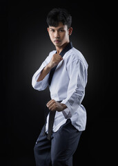Asian taekwondo athlete standing guard on black background
