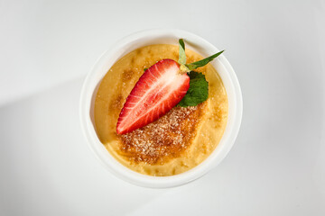 Strawberry-Topped Crème Brûlee Dessert in a White Dish - Close-Up