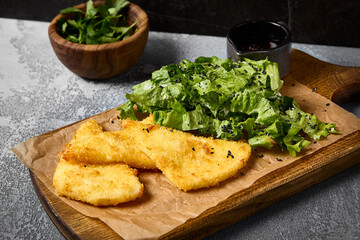 Crispy Fried Cheese with Mixed Greens and Berry Sauce on Wooden Board
