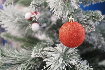 Closeup of a beautifully decorated Frosted Pine Christmas Tree with a Red Bauble