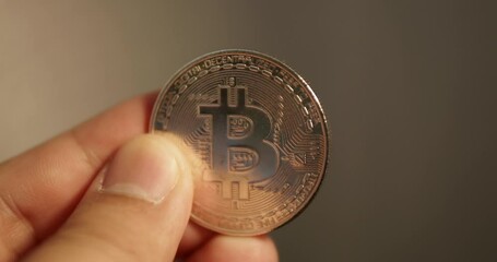 Blurry close-up shot of a golden commemorative coin in Thai Baht currency being flipped by an individual in his or her hand.